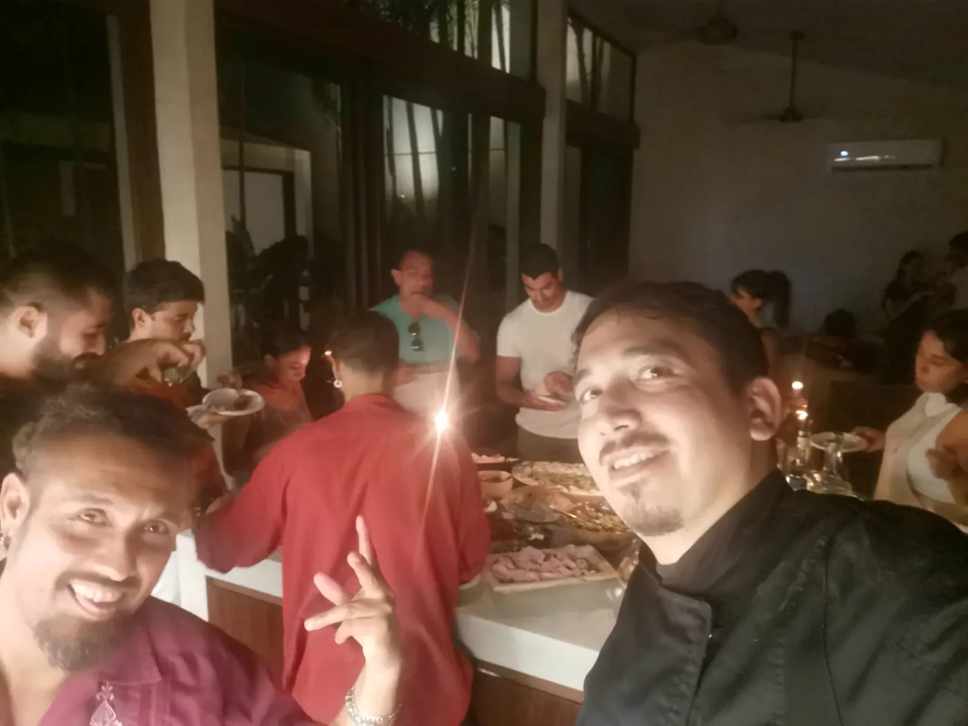 The chef with guests gathered around a villa buffet