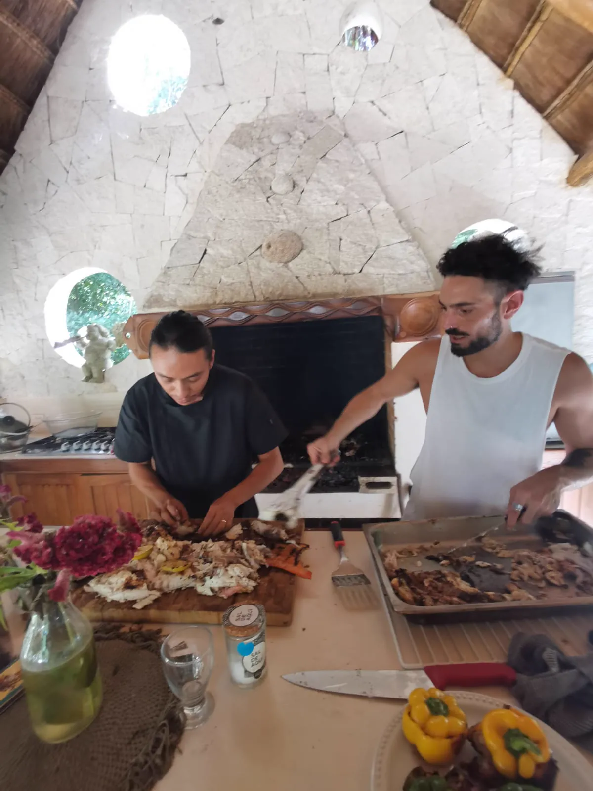 Two cooks working a palapa kitchen over the hearth